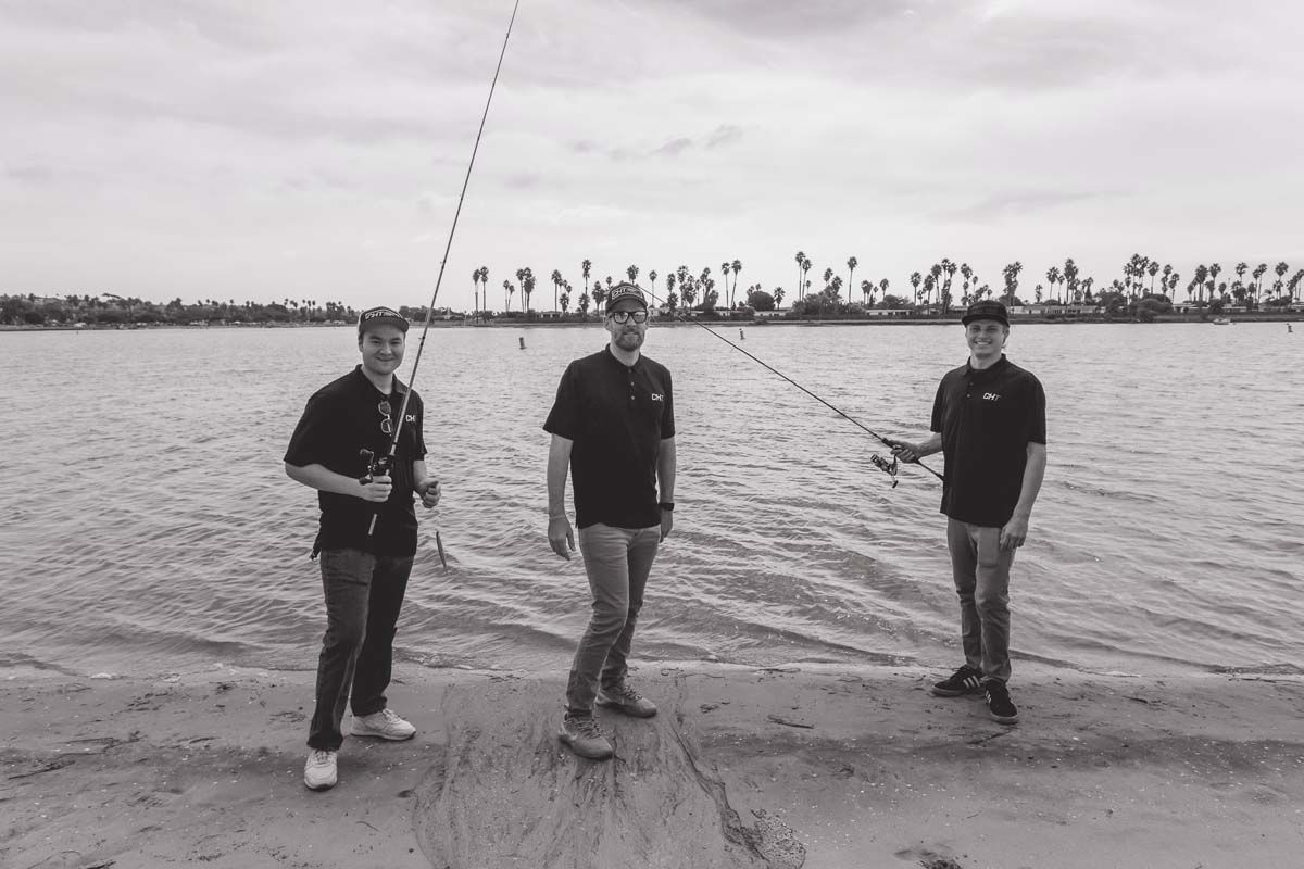 Black and white photo, three men fishing
